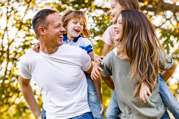 istock Carefree parents and their small kids having fun while piggybacking in springtime. 1249174604