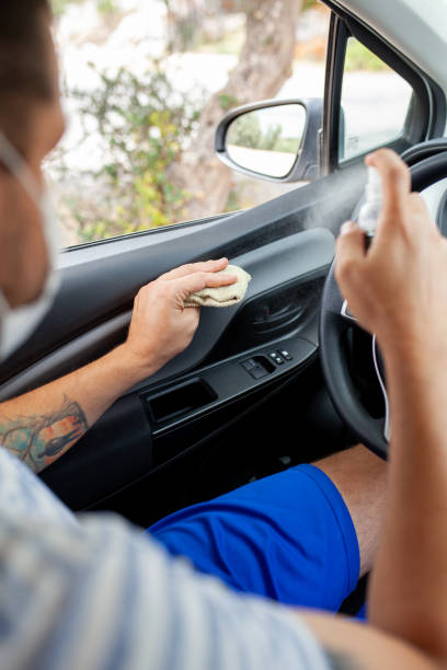 istock Man spraying with disinfection liquid and cleaning his car 1249174685