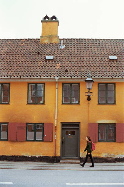 Young Caucasian woman in green sweater with backpack walking in Copenhagen