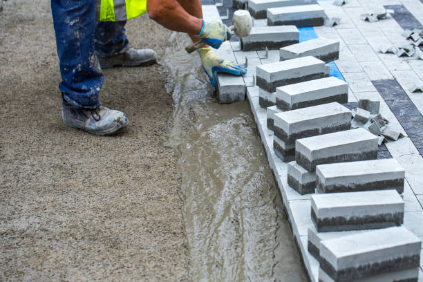 istock Construction work on pavement. Installation of concrete paver blocks on the sidewalk. The worker pavers pavement bricks on a pre-prepared surface of concrete mortar. 1249177239