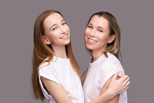 Elder mother and teenager daughter hug. Happy family portrait. Similar smile. Next generation love. Single mom. Mature parent. Smiling people group. Attractive posing together. Two hand connection