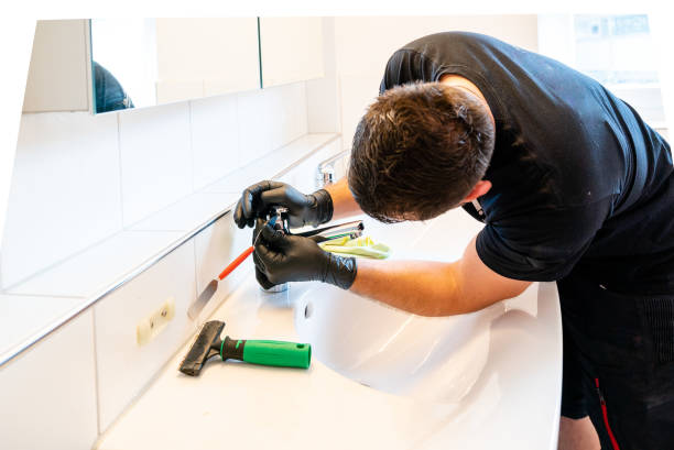 istock man cleaning a bathroom sink with a scraper blade and micro fiber cloth to remove lime and stains 1249181429
