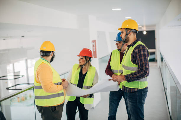 istock Engineers and architects looking at building blueprint at the construction site 1249186156