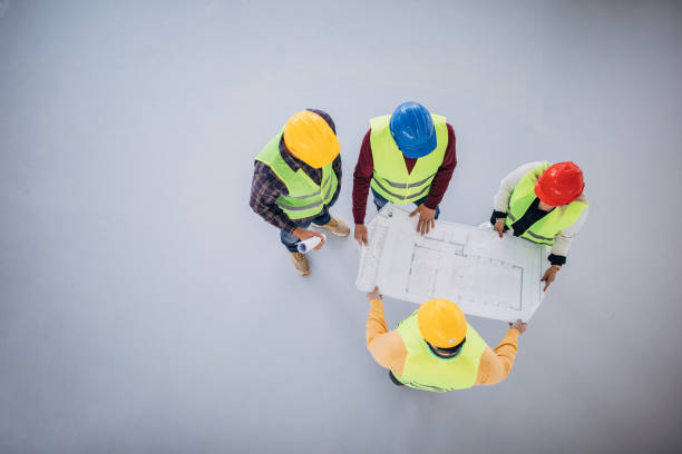 istock Engineers and architects looking at building blueprint at the construction site 1249186166