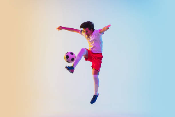 istock Football or soccer player on gradient background in neon light - motion, action, activity concept 1249186273