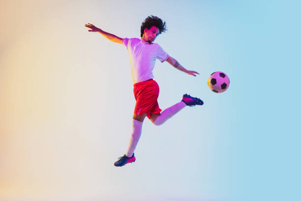 istock Football or soccer player on gradient background in neon light - motion, action, activity concept 1249186277