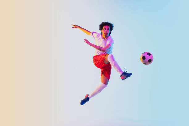 istock Football or soccer player on gradient background in neon light - motion, action, activity concept 1249186281