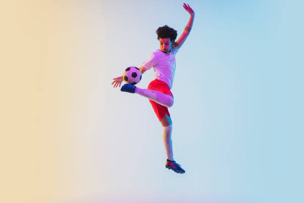 istock Football or soccer player on gradient background in neon light - motion, action, activity concept 1249186282
