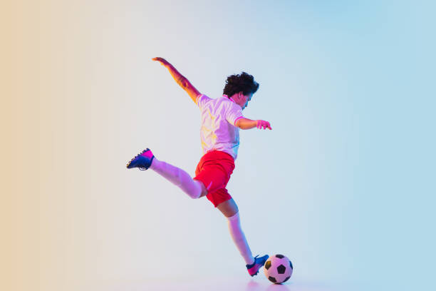 istock Football or soccer player on gradient background in neon light - motion, action, activity concept 1249186283