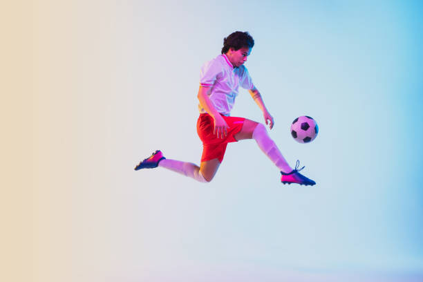 istock Football or soccer player on gradient background in neon light - motion, action, activity concept 1249186288
