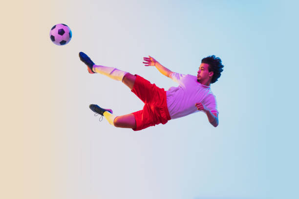 istock Football or soccer player on gradient background in neon light - motion, action, activity concept 1249186291