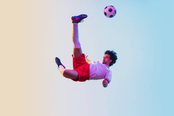 istock Football or soccer player on gradient background in neon light - motion, action, activity concept 1249186292