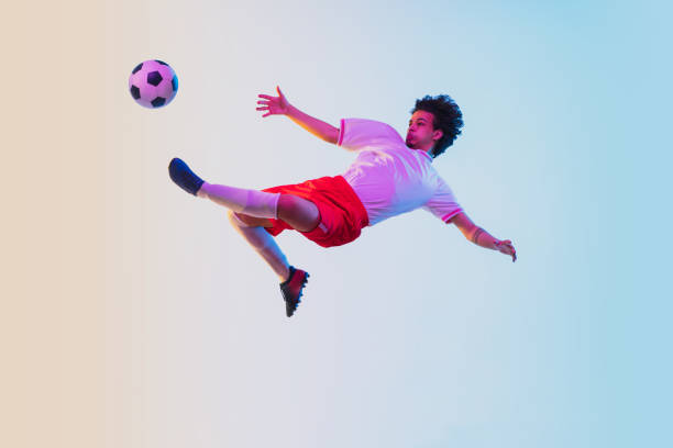istock Football or soccer player on gradient background in neon light - motion, action, activity concept 1249186294