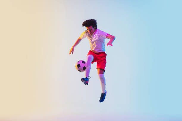 istock Football or soccer player on gradient background in neon light - motion, action, activity concept 1249186295