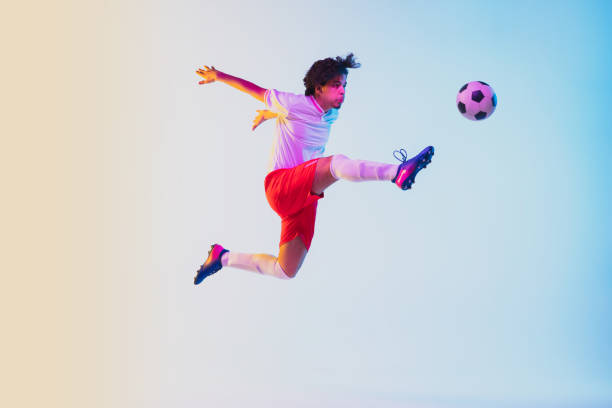 istock Football or soccer player on gradient background in neon light - motion, action, activity concept 1249186296