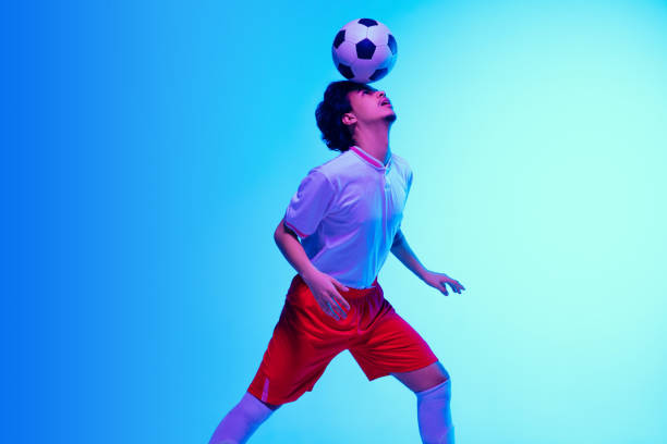 istock Football or soccer player on gradient background in neon light - motion, action, activity concept 1249186299