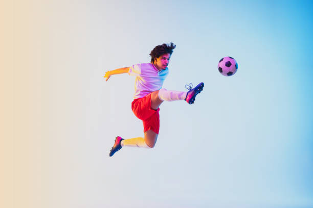 istock Football or soccer player on gradient background in neon light - motion, action, activity concept 1249186300