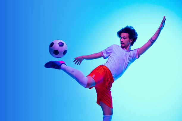 istock Football or soccer player on gradient background in neon light - motion, action, activity concept 1249186308