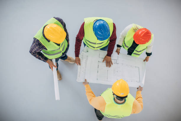 istock Engineers and architects looking at building blueprint at the construction site 1249186363