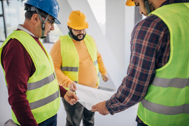 istock Male architects looking at building plan at the construction site 1249186459