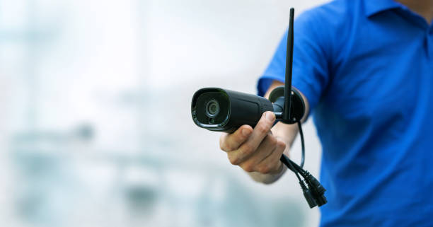 istock security cameras and cctv services background - man holding ip camera in hand with copy space 1249189911