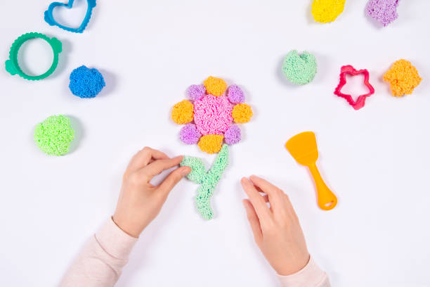 istock Early development concept. Hands play with modeling clay and making flower 1249196473