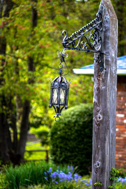 istock Old lantern on wooden pole with trees 1249198266