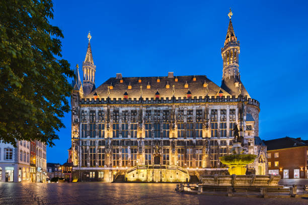 Old Aachen Town Hall At Night The famous old town hall of Aachen, Germany with night blue sky seen from the market square with the Karls fountain to the right. Taken with a shift lens for straight perspective. aachen photos stock pictures, royalty-free photos & images