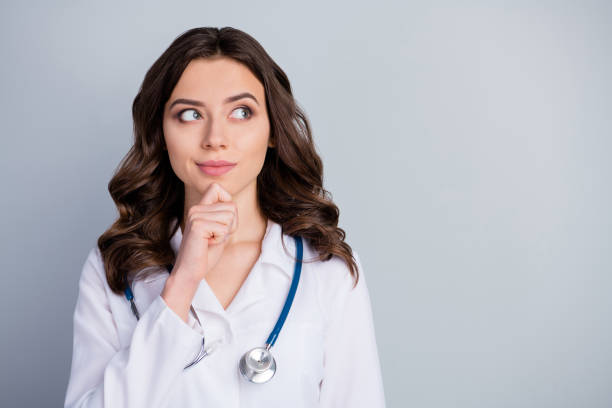 foto von attraktiven familie doc dame patienten beratung virologie klinik aussehen seite leer raum interessiert hand auf kinn tragen weiße labor mantel stethoskop isoliert grau farbe hintergrund - lab coat women one person female stock-fotos und bilder