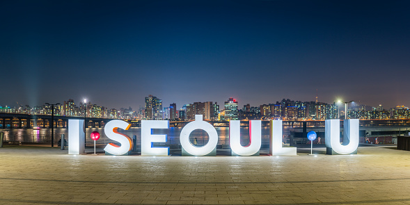 I SEOUL U sign popular public selfie location in Yeouido Hangang Park overlooked by the neon night lights of downtown skyscrapers in the heart of Seoul, South Korea’s vibrant capital city.