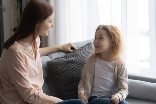 istock Young mom and little daughter relax on sofa talking 1249199751