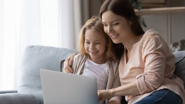 istock Smiling mom and little daughter using laptop at home 1249199767