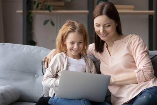 istock Smiling young mom and little daughter use laptop 1249199774