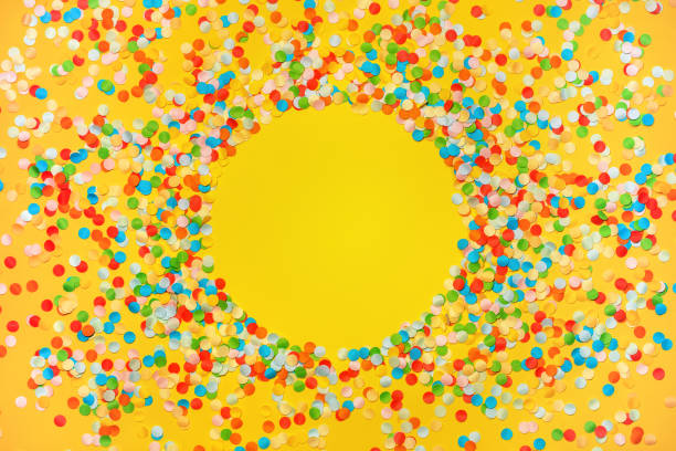 istock Yellow background with vivid confetti. Colorful abstract backdrop with round frame and space for your text. Festive composition for celebration. View from above. Flat lay. 1249200475