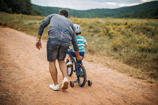 istock Father teaches son to ride a bike 1249201810