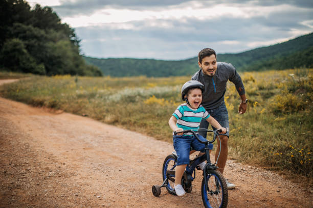 istock Father teaches son to ride a bike 1249202001