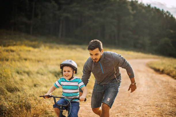 padre enseña a su hijo a andar en bicicleta - 3498 fotografías e imágenes de stock