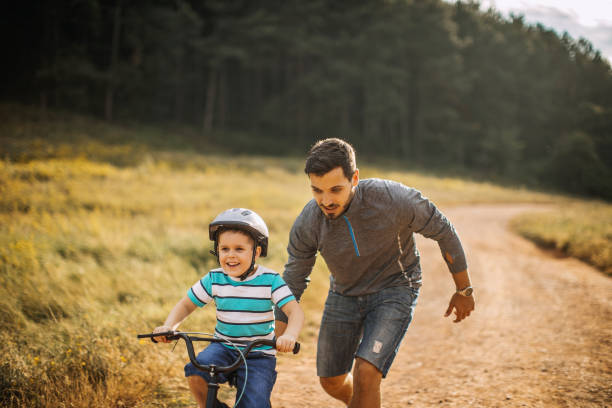 padre insegna al figlio a andare in bicicletta - 3498 foto e immagini stock