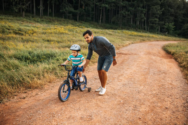 istock Father teaches son to ride a bike 1249202103