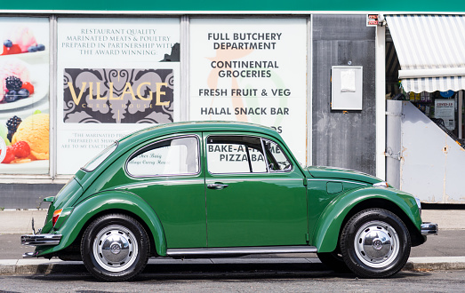Glasgow, Scotland - Side view of a vintage Volkswagen Beetle, parked on a street in Glasgow's Southside.