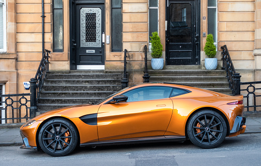 Glasgow, Scotland - Side view of a gold coloured Aston Martin Vantage (2018 onwards model) on a residential street.