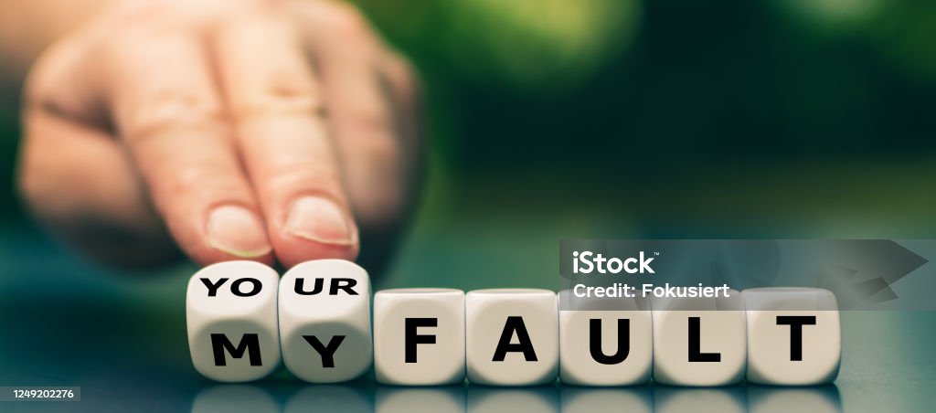 Hand turns dice and changes the expression "my fault" to "your fault". Guilt Stock Photo