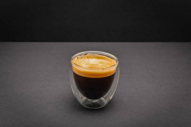 свежесваренный сливочный эспрессо в стеклянной кофейной чашке, изолированной на сером и черном фоне, крупным планом с копировальной площа� - coffee cup black coffee isolated стоковые фото и изображения