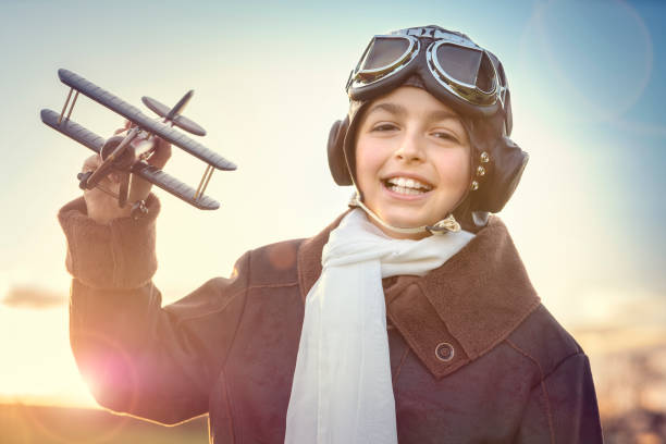 istock Boy playing with wooden toy airplane 1249202617