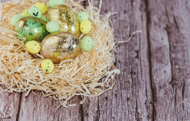 istock Easter eggs in nest with candle and flowers on rustic wooden background 1249203613