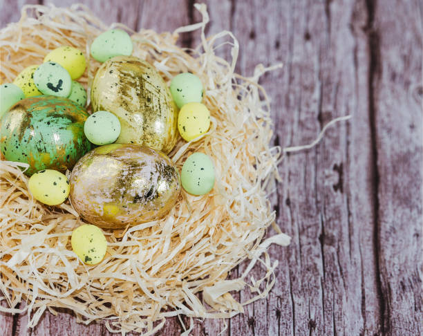 istock Easter eggs in nest with candle and flowers on rustic wooden background 1249203636