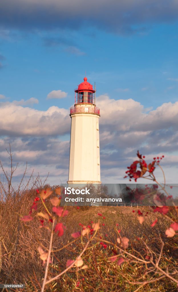 so called Dornbusch, the Lighthouse of the island Hiddensee in autumne north of Germany, Cloudy sky red leafes in the foreground Baltic Sea Stock Photo