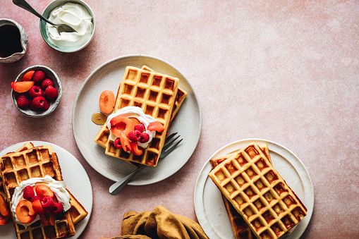 Top view of plate of homemade waffle served with strawberry and raspberry. Preparing homemade waffle breakfast.