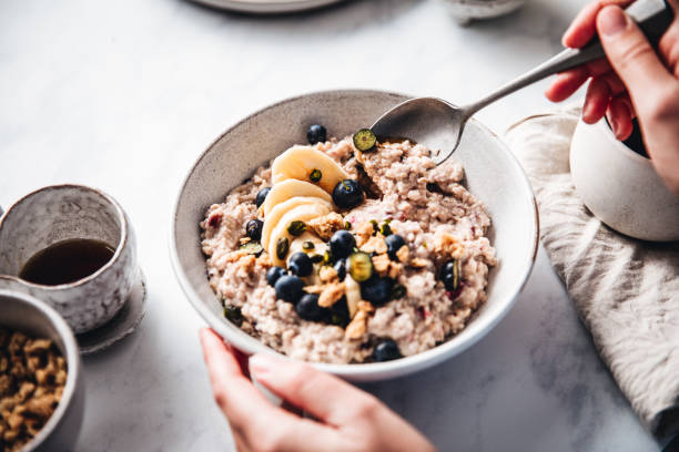 frau macht gesundes frühstück in der küche - frühstück fotos stock-fotos und bilder