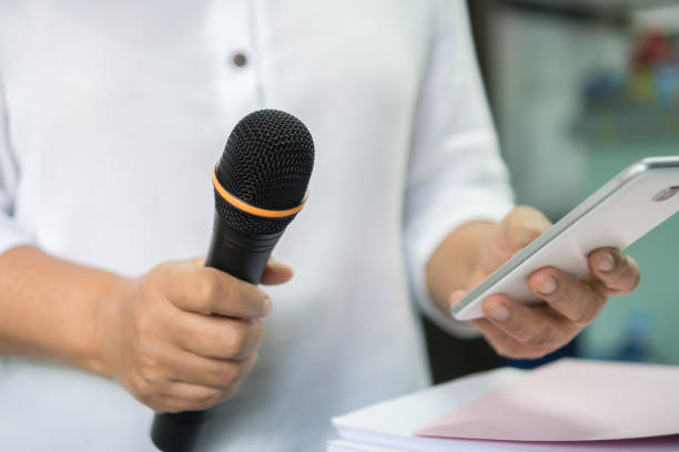 istock Teacher or business man hold microphone for teaching on speech or speaker at seminar conference with smartphone for speaking at auditorium room while explaining gesturing in classroom in university 1249207933